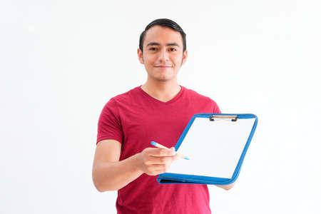 young man handing a table with a sheet of paper and pen to write down, on a white backgroundの写真素材
