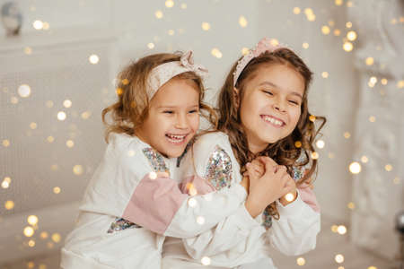 Two sisters are sitting and having funの写真素材