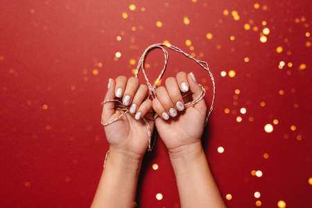 christmas white manicure on a red backgroundの写真素材