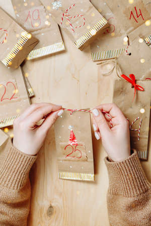 Handmade advent calendar on a wooden background with a place to writeの写真素材