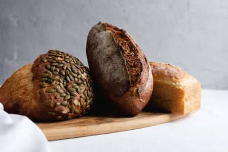Rye bread on a board on a white tablecloth backgroundの写真素材