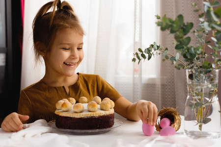 Little girl is happy about Easter breakfast.の写真素材