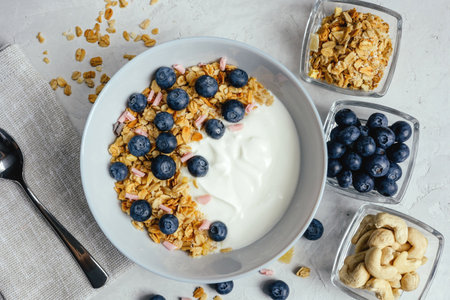 Yogurt with muesli and fresh blueberries on a gray background, perfect breakfast.の写真素材