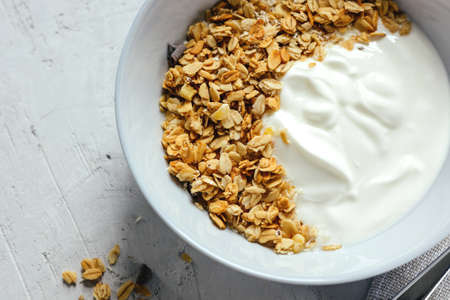 Yogurt with muesli and fresh blueberries on a gray background, perfect breakfast.