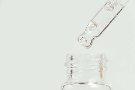 Pipette with a glass bottle on a white background and with oil.の写真素材