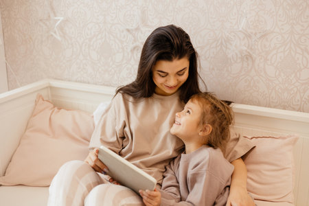 Mom and daughter look at the tablet.の写真素材