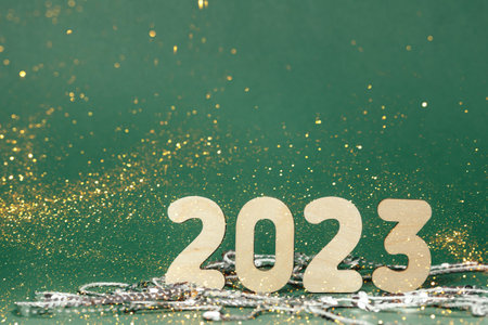 A glass of champagne and numbers of the year on a background of sequins