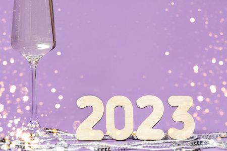 A glass of champagne and numbers of the year on a background of sequinsの写真素材