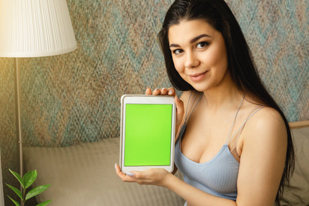 A girl behind the phone with a green screenの写真素材
