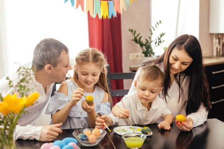 A friendly family paints Easter eggs and laughs.の写真素材