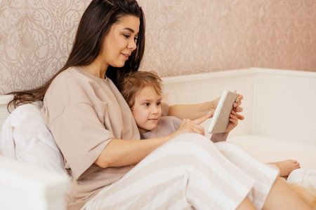 Mom and daughter look at the tablet.の写真素材