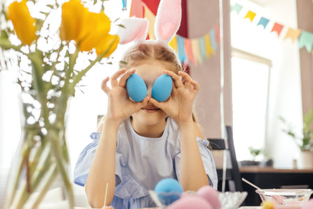 Cheerful little girl plays with Easter eggs.の写真素材