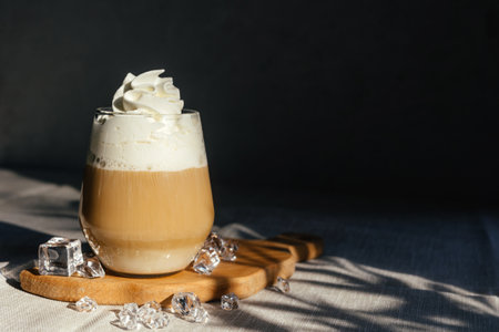 Coffee latte on a gray table in bright sunlight and free space. Cold summer coffee with ice. gray background.の写真素材