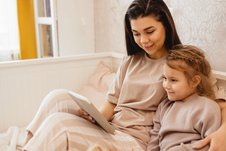 Mom and daughter look at the tablet.の写真素材