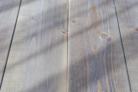 Wooden background with shadows from the sun. Place for text.