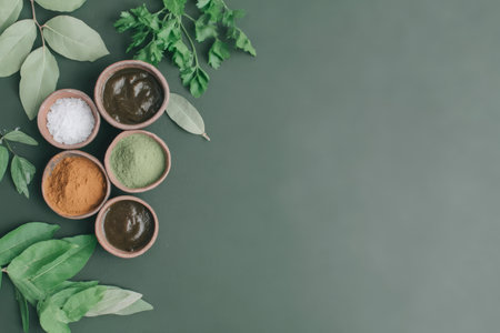 Herbal powders and fresh leaves on green background for natural skincare.の素材