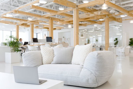 Modern open-concept office space with wooden beams and comfortable seating.の素材