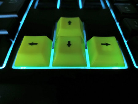 Close Up of Yellow Arrow Key with Neon Cyan Keyboard Lit Around