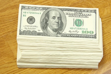 big pile of money over wood backgroundの写真素材