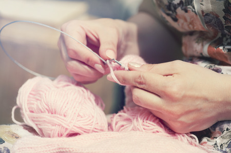 The woman knits woolen clothes.