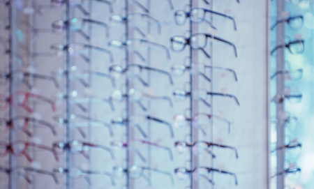 Blur glasses on display shelves in glasses store background