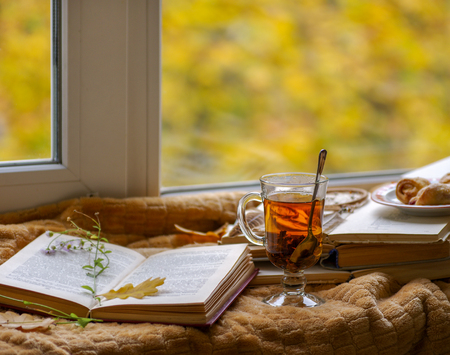 Hot tea in the background of a window and autumn nature.の写真素材