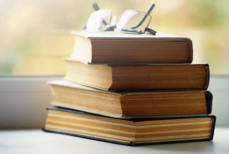 Book on a window sill, illuminated by sunlight.
