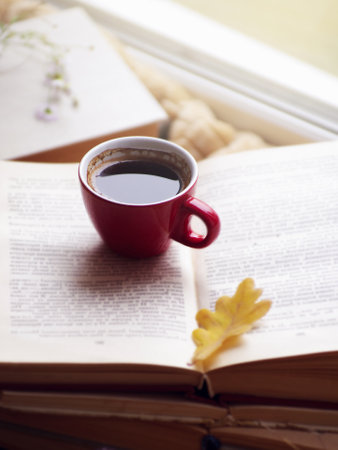 Hot coffee in the background of a window and autumn nature.の写真素材