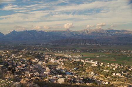 Panorama of the city, valley and cultivated fields in beams of the evening sun. View from the ruined Lekuresi Castle. Nature and travel. Albania, Vlora County, near Sarandaの写真素材