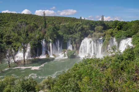 Beautiful view of the Kravica waterfalls after heavy rains. Large tufa cascade on the Trebizat River, in the karstic heartland of Herzegovina. Lush surrounding and rich riparian ecosystem. Nature and travel. Bosnia and Herzegovinaの写真素材