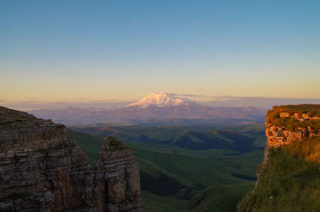 Sunrise over the Bermamyt Plateau. Scenic view of the two summits of the Mount Elbrus - highest and...