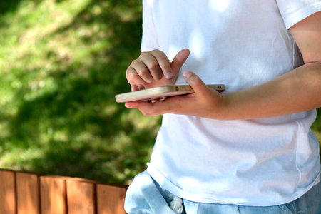 A child uses a smartphone on the street. Gadgets and kids. Use a smartphone. Use a smartphoneの写真素材