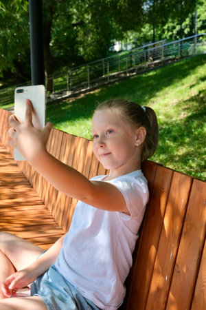 A child uses a smartphone on the street. Gadgets and kids. Use a smartphone. Use a smartphoneの写真素材