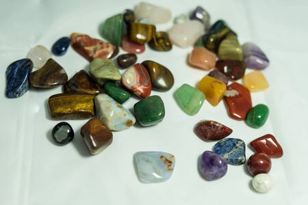 colored round pebbles lie on a white background