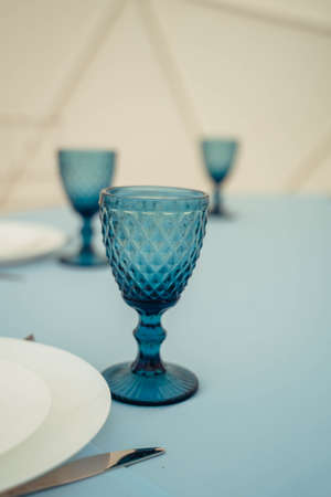 Blue glasses and plates for the wedding stand on a blue tablecloth on the tableの写真素材
