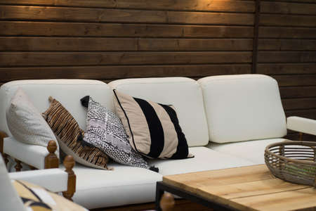 a white sofa with pillows stands on the verandaの写真素材