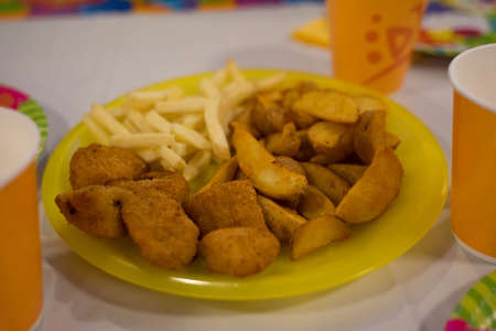 fries and country style potatoes on a plateの写真素材