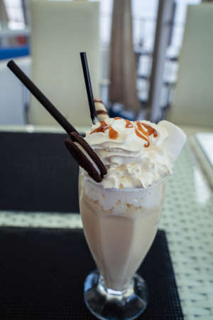 milkshake in a glass glass with a strawの写真素材