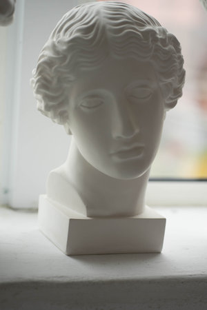 white plaster sculptures stand on the windowsillの写真素材