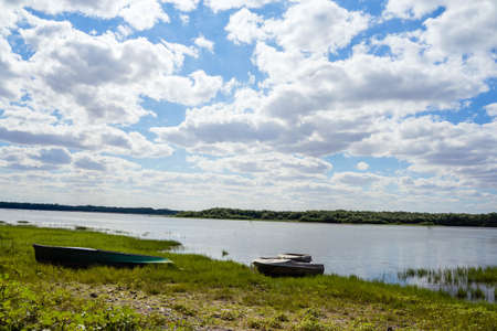 blue river on a background of green forest and grassの写真素材
