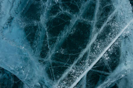 white cracks in transparent ice on the lake