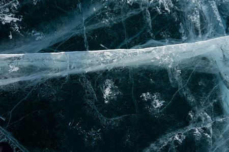 white cracks in transparent ice on the lakeの写真素材
