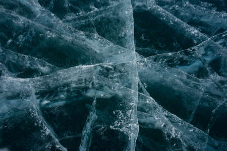 white cracks in transparent ice on the lakeの写真素材