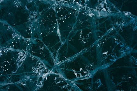 white cracks in transparent ice on the lakeの写真素材
