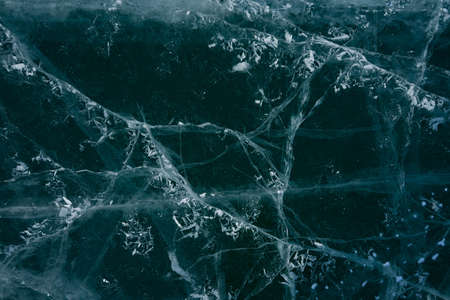 white cracks in transparent ice on the lakeの写真素材