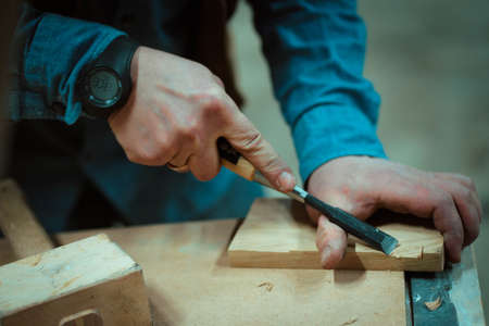 a man makes furniture, cutting details with toolsの写真素材