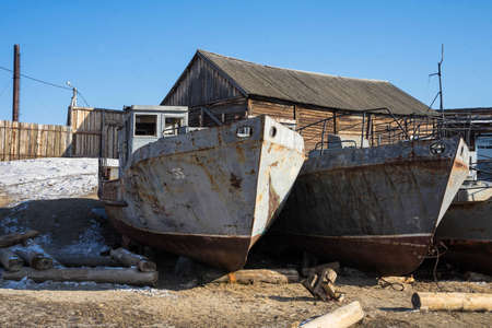 old rusty boats stand on the sandy shoreの写真素材