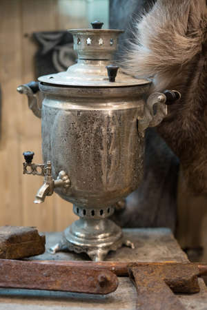 a large metal samovar stands on a wooden standの写真素材