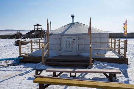 white yurt in the winter in the sun during the day