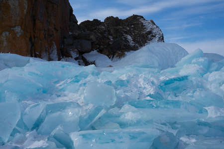 rocks with ice overlaps and icicles near the lake